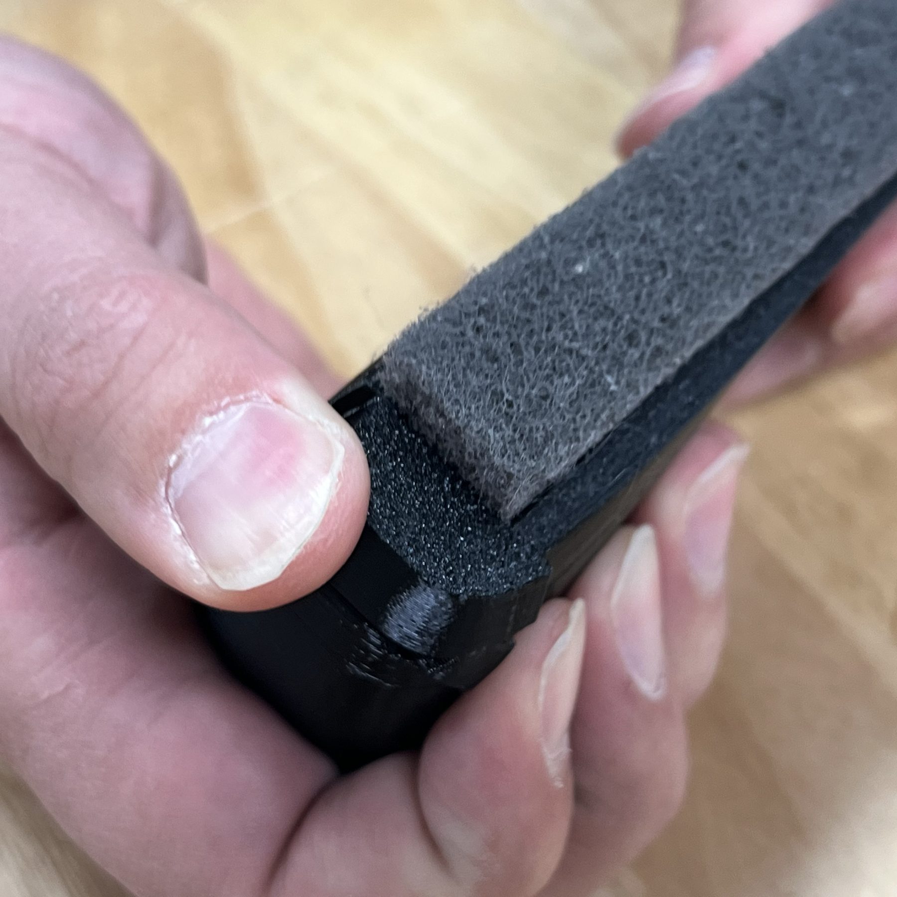 Thumb sliding the end cap off the brush body