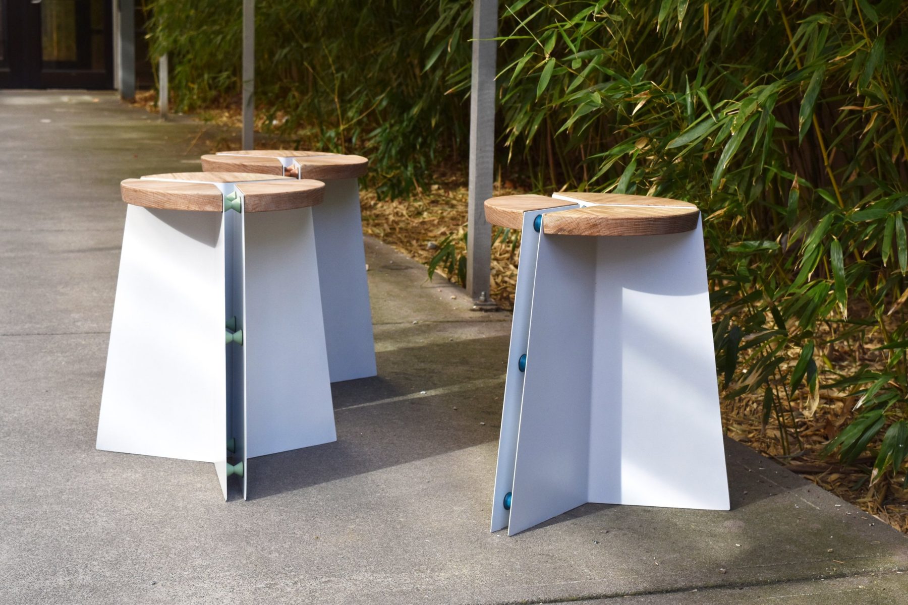 Three finished stools on a terracotta floor